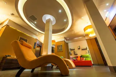 a living room with a chair in front of a mirror at Młyn Jacka Hotel & Spa in Wadowice