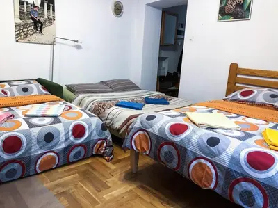 a room with three beds with colorful blankets at Sunny apartment. 5 minutes walk from Main Sqare. in Kraków