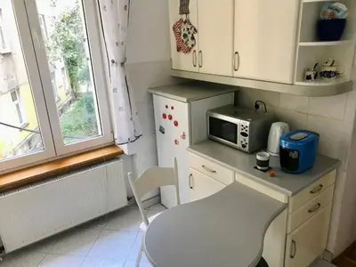 a small kitchen with a table and a microwave at Sunny apartment. 5 minutes walk from Main Sqare. in Kraków