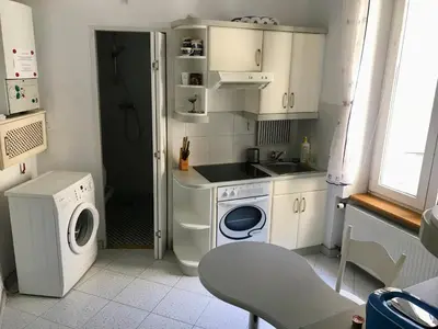 a small kitchen with a washing machine and a sink at Sunny apartment. 5 minutes walk from Main Sqare. in Kraków