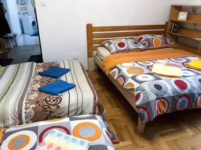 a room with two beds with colorful blankets at Sunny apartment. 5 minutes walk from Main Sqare. in Kraków