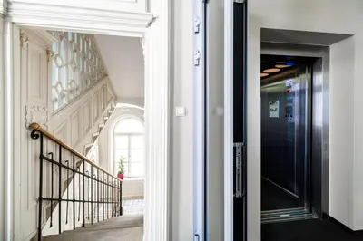 a hallway with a black door and a staircase at Home Aparthotel in Kraków