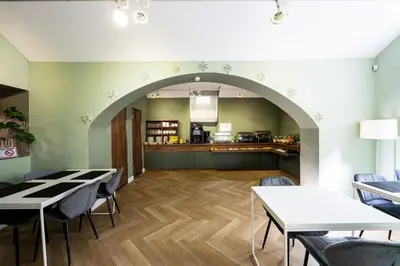 a restaurant with tables and chairs and a counter at Home Aparthotel in Kraków