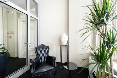 a black chair in a room with plants at Home Aparthotel in Kraków