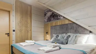 a bedroom with a bed with towels on it at Skansen Holiday in Cholerzyn