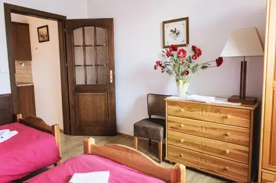 a bedroom with a dresser and a vase of flowers at Dworek Galicyjski in Oświęcim