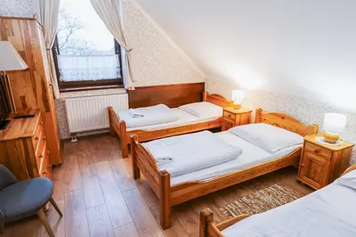 a room with three beds and a window at Dworek Galicyjski in Oświęcim