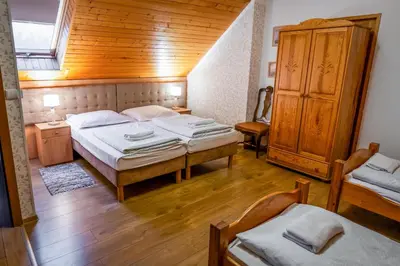 a bedroom with two beds and a wooden ceiling at Dworek Galicyjski in Oświęcim