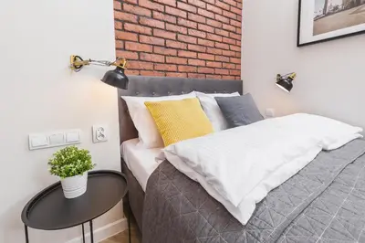 a bedroom with a bed and a brick wall at Agnes Apartments Old Town in Kraków