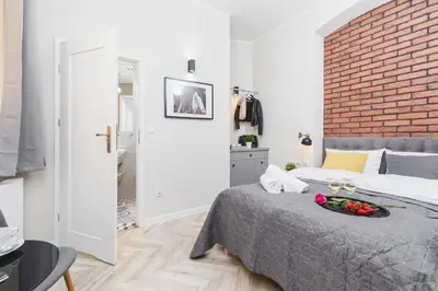 a bedroom with a bed and a brick wall at Agnes Apartments Old Town in Kraków
