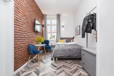 a bedroom with a bed and a brick wall at Agnes Apartments Old Town in Kraków