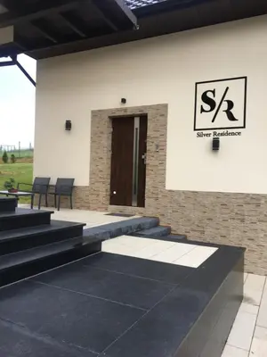 a building with stairs and a sign on the wall at Silver Residence in Rabka