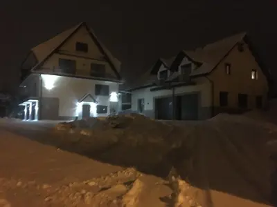 a group of houses in the snow at night at Silver Residence in Rabka
