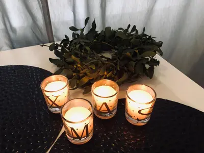 four candles on a table with a potted plant at Nico Apartments in Kraków