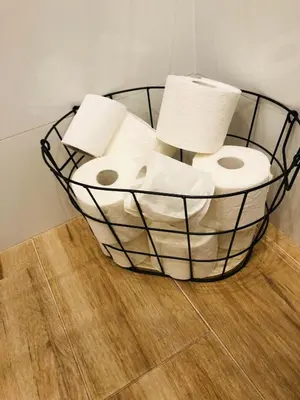 a basket filled with toilet paper on a wooden floor at Nico Apartments in Kraków