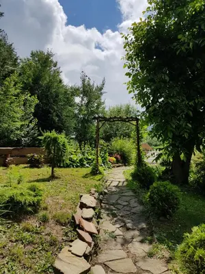 a garden with a stone path and a wooden arch at Na Stawach in Stryszów