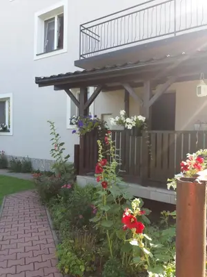 a house with a porch with flowers on it at Lawendowe Siedlisko in Zator