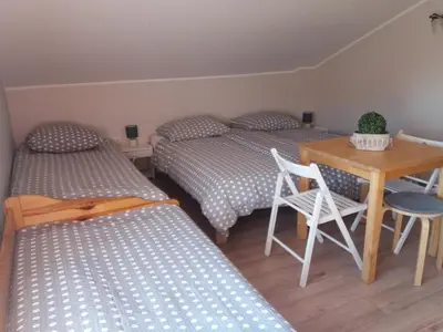 a bedroom with two beds and a table and a table and chairs at Lawendowe Siedlisko in Zator