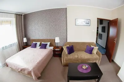 a hotel room with a bed and a chair at Villa Green in Oświęcim