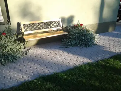 a wooden bench sitting in front of a building at Villa Green in Oświęcim