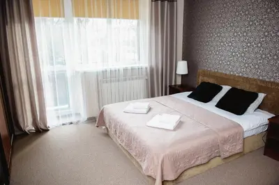 a bedroom with a large bed with two towels on it at Villa Green in Oświęcim