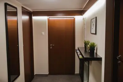 a hallway with a brown door and a black table at Villa Green in Oświęcim