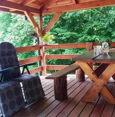 a wooden deck with a wooden table and a bench at Bacówka na Leśnej in Po”łwieś