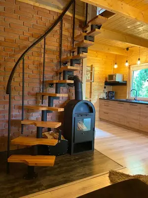 a wood stove in a room with a brick wall at Bacówka na Leśnej in Po”łwieś