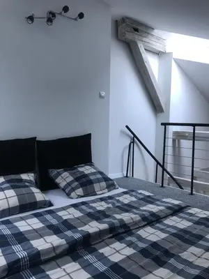 a bed with two pillows on it in a room at Klimatyczny apartament przy bocheńskim Rynku. in Bochnia
