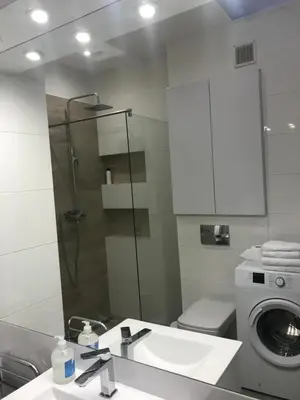 a bathroom with a sink and a washing machine at Klimatyczny apartament przy bocheńskim Rynku. in Bochnia