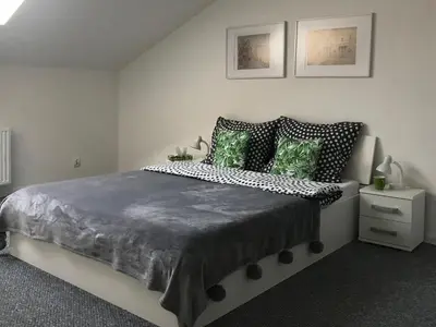 a bedroom with a large bed with green pillows at Klimatyczny apartament przy bocheńskim Rynku. in Bochnia