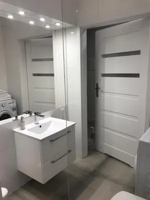a bathroom with a sink and a glass door at Klimatyczny apartament przy bocheńskim Rynku. in Bochnia