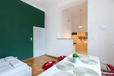 a living room with a white table and red chairs at Fresh Apartments in Kraków