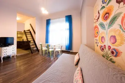 a living room with a couch and a dining room at Fresh Apartments in Kraków
