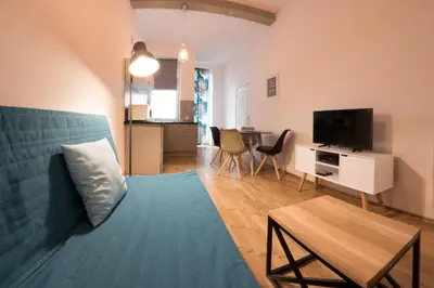 a living room with a blue couch and a television at Fresh Apartments in Kraków