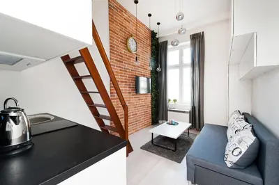 a kitchen and living room with a brick wall at Dietla 99 - Studio by Homeprime in Kraków