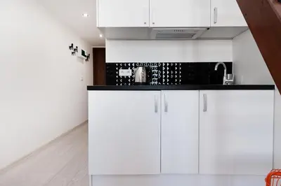 a kitchen with white cabinets and a sink at Dietla 99 - Studio by Homeprime in Kraków