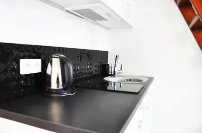 a kitchen with a black counter top and a sink at Dietla 99 - Studio by Homeprime in Kraków
