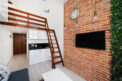 a brick wall with a tv on a brick wall at Dietla 99 - Studio by Homeprime in Kraków