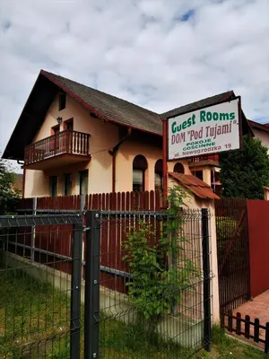 a house with a fence in front of a building at Dom pod Tujami in Kraków