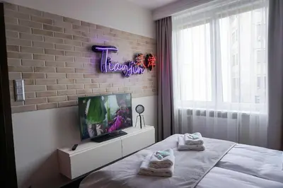 a bedroom with a bed and a tv and a brick wall at AGA Tenis Apartments by Radwańska in Kraków