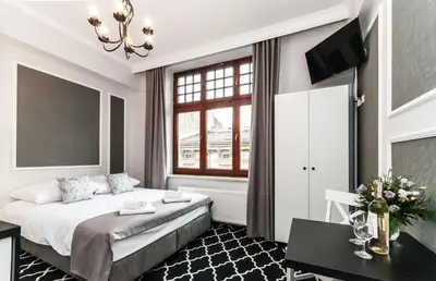 a hotel room with a bed and a window at Apartamenty L5 in Kraków