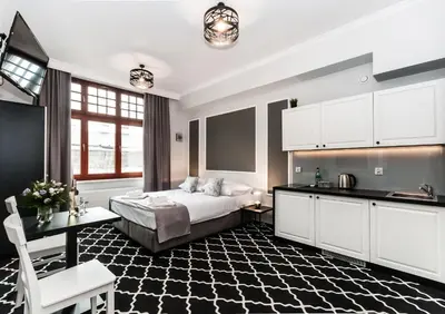 a large bedroom with a bed and a kitchen at Apartamenty L5 in Kraków