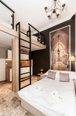 a bedroom with a large bed with a loft bed at Apartamenty L5 in Kraków