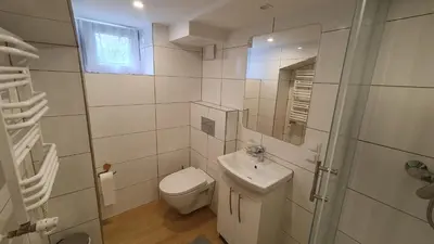 a bathroom with a toilet and a sink and a mirror at Krakow 360 Apartment in Kraków