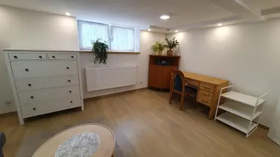 a room with a desk and a dresser and a table at Krakow 360 Apartment in Kraków