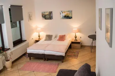 a bedroom with a bed and two lamps and a couch at Za Rabą in Myślenice