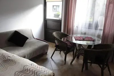 a living room with a couch and a table and chairs at Za Rabą in Myślenice
