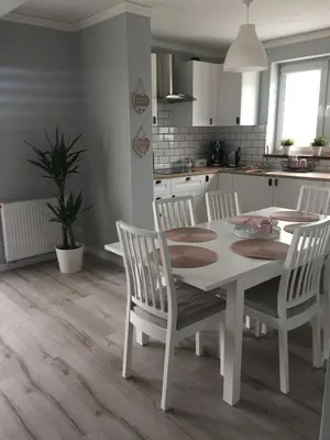 a white kitchen with a white table and chairs at Apartament Julek klimatyzowany in Oświęcim