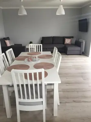a white dining table and chairs in a living room at Apartament Julek klimatyzowany in Oświęcim